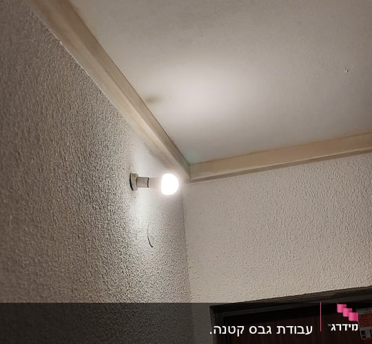 קיר גבס עם מרקם מחוספס ותאורה עליונה